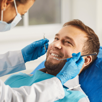 Preventative dental care at go dental: your path to a healthy smile 2 Young man smiling while receiving dental care, representing preventative dental care.