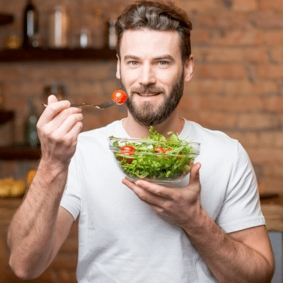 Best foods for strong teeth and gums 2 Man enjoying a healthy salad bowl, representing best foods for strong teeth and gums